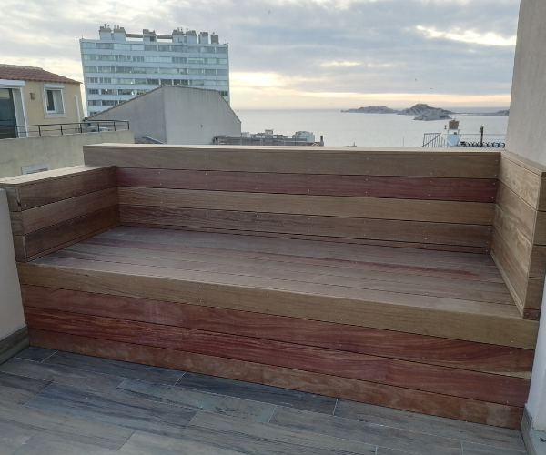 Banc extérieur en bois sur terrasse avec vue mer à Marseille