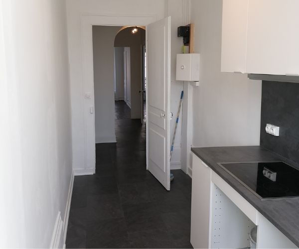 Couloir rénové à Lyon 6 avec nouveaux sols et murs blancs