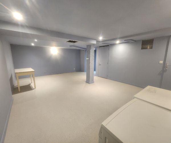 Sous-sol rénové avec ragréage, pose de dalles vinyle, électricité et peinture