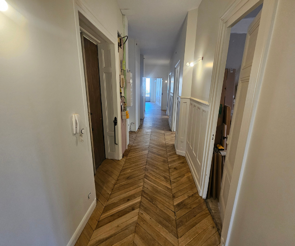 Rénovation d’un couloir à Lyon avec parquet en pointe de Hongrie rénové et murs repeints