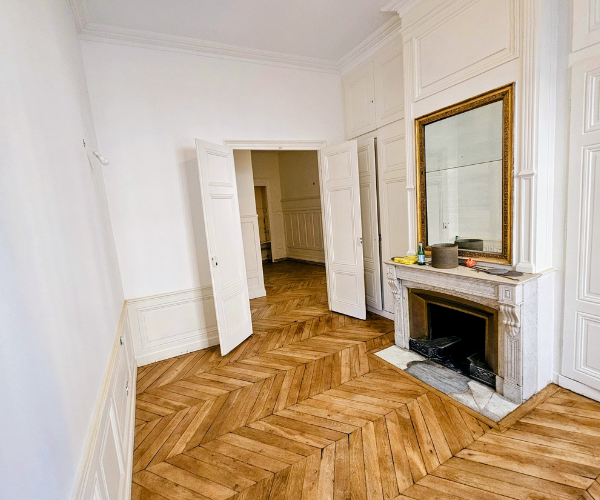 Rénovation d’un salon à Lyon 2 avec parquet en pointe de Hongrie poncé et vitrifié et boiseries restaurées